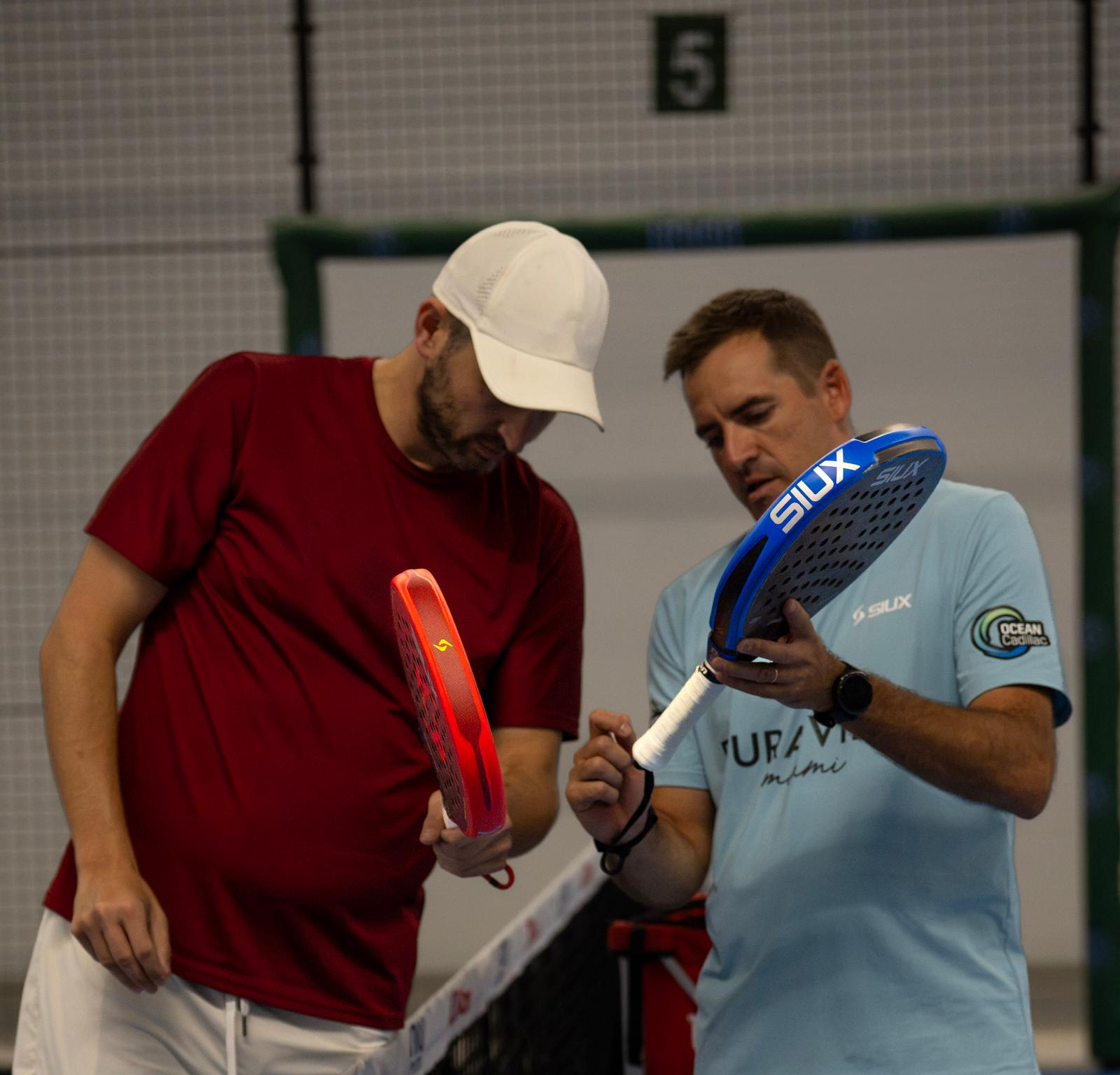 Hands and padel rackets during coaching
